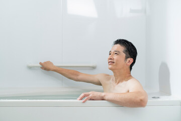 湯船に浸かってリラックスする40代男性