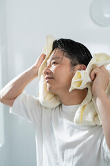 風呂上がりに髪を拭く40代男性