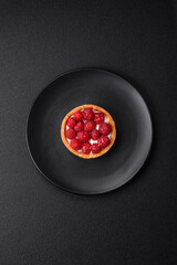 Delicious fresh sweet round tart with ripe raspberries and cream