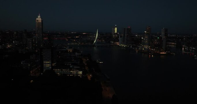 Aerial drone view of the Erasmusbrug, Erasmusbridge, icon of the city of Rotterdam at night. Skyline of the city, urban view.