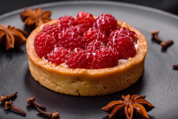 Delicious fresh sweet round tart with ripe raspberries and cream