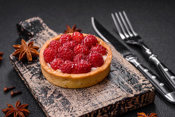 Delicious fresh sweet round tart with ripe raspberries and cream