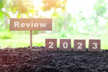 Year 2023 review concept. Wooden blocks typography in natural background. - obrazy, fototapety, plakaty