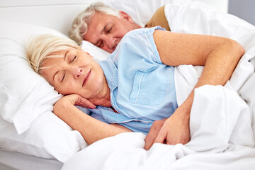 Sleeping, bedroom and senior couple with love, relax and retirement on a weekend break, resting and calm. Peace, old woman or elderly man in a bed, home or morning with care, marriage or relationship