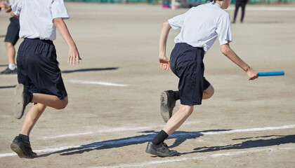 中学校の運動会のリレーに走る男性生徒の姿