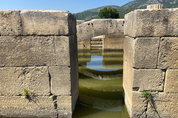 Ceiling ruins of ancient stone temple of Apollon in Klaros ancient city filled water, top arches...