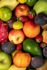 Close-up fresh colorful fruits background. Mixed fruit. Close-up. Grape, Fig, Strawberry, apple, pear, kiwi, peach. Top view