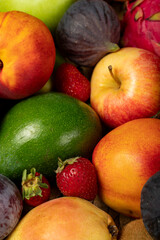 Fresh ripe colorful organic fruits from market: apple and fig, strawberry and peach, grape and apricot; healthy fruit background