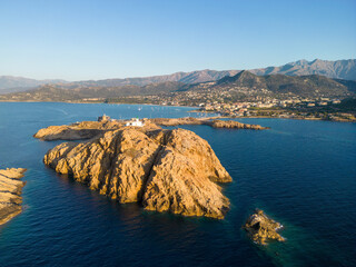 Aerial view of La Pietra lighthouse and island at Ile Rousse in Corsica - 654748051