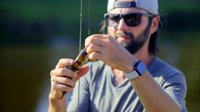 fisherman taking perch off hook
