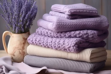 Fotobehang Stack of warm knitted clothes with lavender for autumn and winter seasons © The Big L