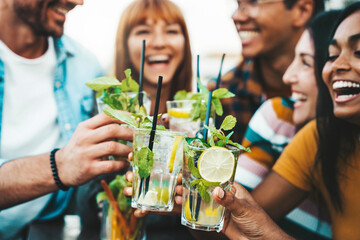 Multiracial friends enjoying happy hour toasting fresh mojito cocktails at open bar - Happy group of young people celebrating summer party together - Life style food and beverage concept - obrazy, fototapety, plakaty