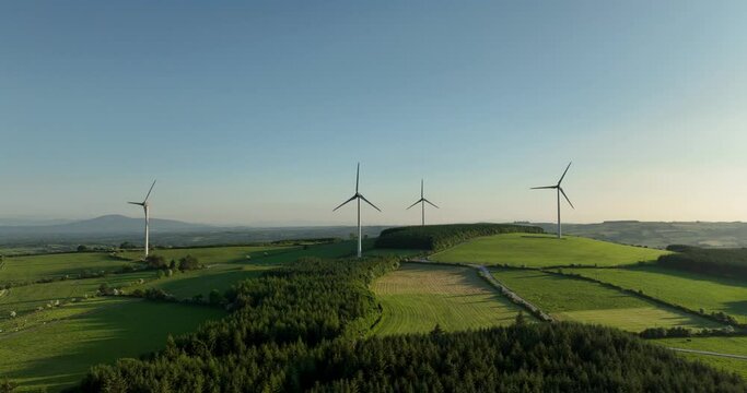 Four wind turbines stand at sunset4k
