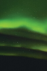 Bright green aurora borealis. Night starry sky and Northern lights