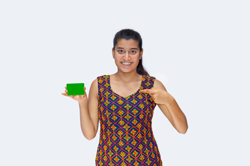 Extremely Happy, Satisfied Girl pointing at Green Screen on Credit Card, against white background