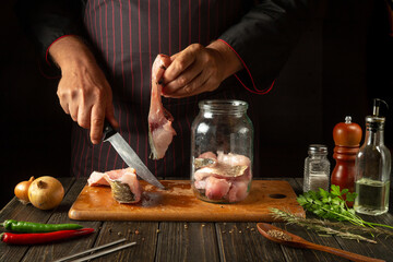 Cutting raw carp fish for preparing herring in a jar or canning. Knife in the hand of the cook and...