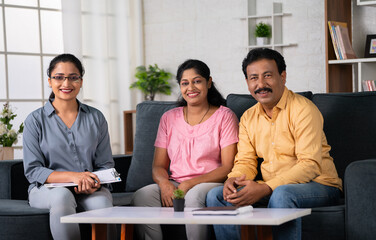 Portrait shot of Happy indian psychologist with middle aged couple looking at camera after...