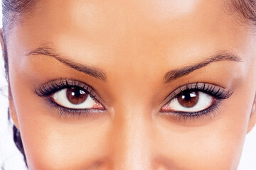 close-up of models brown eyes wearing make-up taken in a studio with soft boxes reflected in eyes 