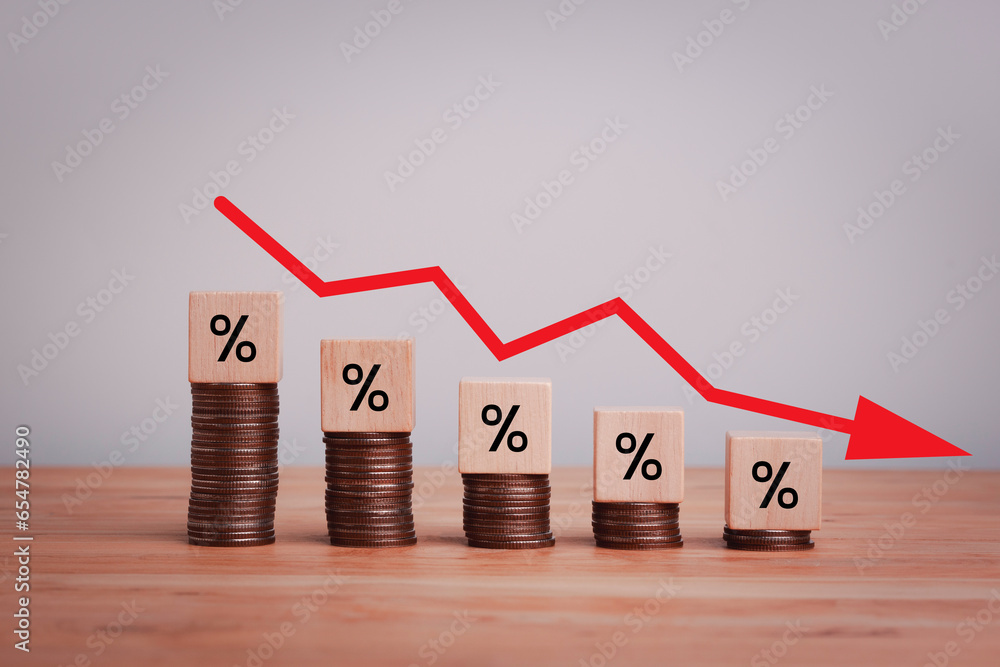 Poster percentage sign on wooden cubes with stack of coin bar chart and red graph trending downwards on whi