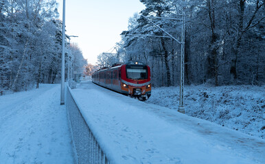 Pociąg wjeżdżający na stację kolejową zimą - obrazy, fototapety, plakaty