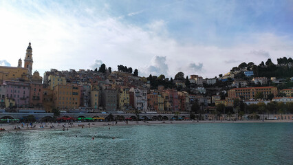 Fototapeta na wymiar Menton, France, October 6, 2021: Sablettes beach in Menton is located between the two ports (the Old Port and Garavan), along the Quai Bonaparte and the old town.