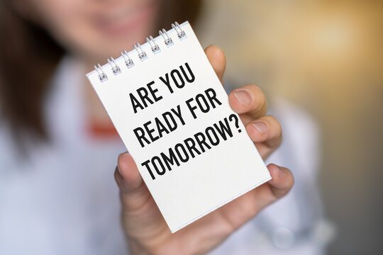 Closeup on Female holding a card with text ARE YOU READY FOR TOMORROW, business concept image with soft focus background and vintage tone