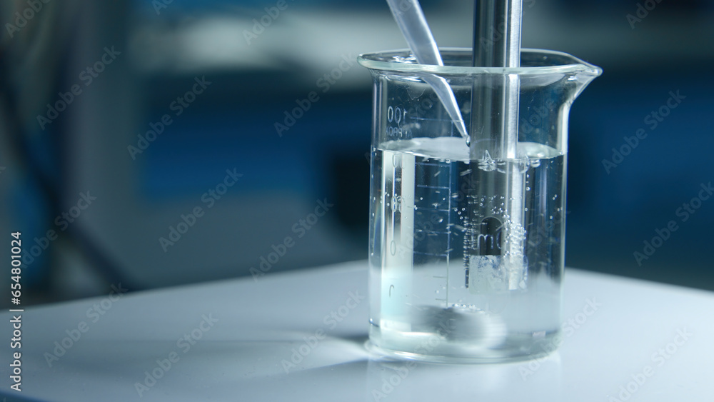 Poster rotating substance in glass of liquid in laboratory. stock footage. chemical experiment with substan