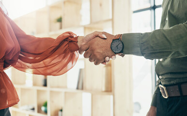 Creative people, handshake and partnership in meeting, b2b deal or teamwork together at office. Closeup of man and woman shaking hands for startup, introduction or thank you in agreement at workplace