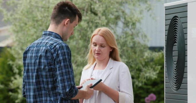 A young engineer advises a client in setting up a heat pump