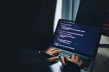 Person, hands and hacker on laptop at night in cybersecurity, coding malware or software at home....