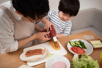 ホットドッグの作り方を子供に教えるお父さん