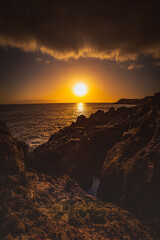 sunset over the sea on a rocky coast