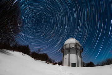 Star tracks across north celestial pole with telescope dome on a foreground - obrazy, fototapety, plakaty