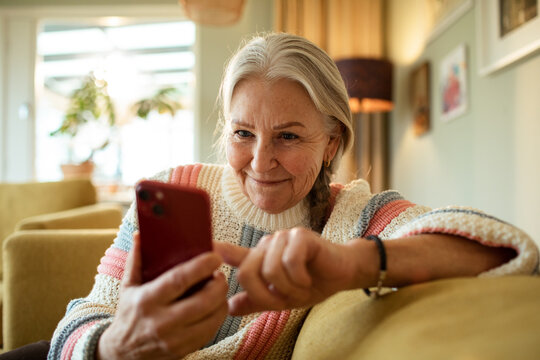 Senior Caucasian woman using her smartphone on the couch at home
