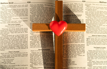wooden cross heart on the background of the bible