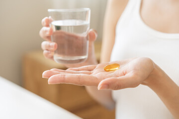 Dietary supplement, asian young woman, girl hand holding medical pill capsule, take or eat vitamin...
