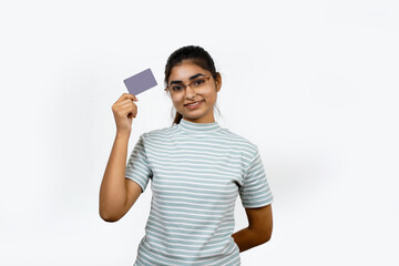 Beautiful young blonde woman holding up a credit card while avoiding her eyes from the copy space...