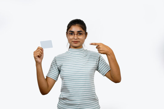 Beautiful young blonde woman holding up a credit card while avoiding her eyes from the copy space in the picture pose.