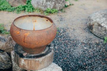 Naklejka premium the cast-iron pot stands on a wooden stand. Rustic style