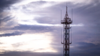 A photograph, of an antenna, used for communication, with the background, the sun, in the morning.