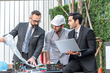 Two Businessman and power engineering talking and checking quality power solar cell with laptop...