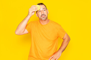 Hispanic man with beard in his 40s complaining about summer heat isolated on yellow background....