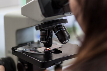 Unidentified person observing through a microscope