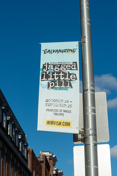 street pole banner advertising a Mirvish production of Alanis Morisette's "Jagged Little Pill" stage production outside on a blue sky