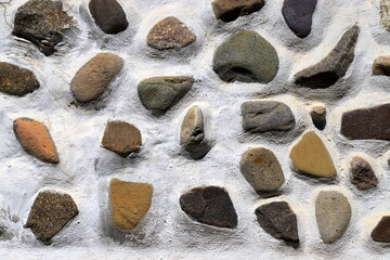 Pebble wall, path, sidewalk. Gray, yellow pebbles, cement, background, stone structure