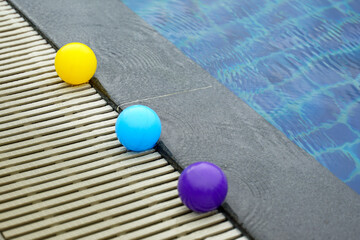 Spherical balls lined up along the edge of the swimming pool are the source of three circular waves...