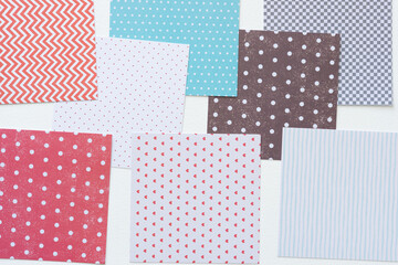 square paper shapes with various patterns overlapping on blank paper