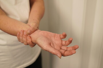A woman uses her other hand to feel pain and tingling. along with Guillain-Barre syndrome and...