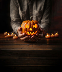 hands holding a halloween illuminated pumpkin