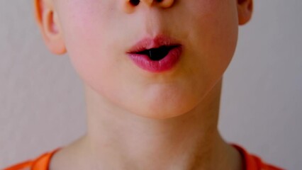 close-up of part of child's face, child, boy 8-10 years old enjoys sweets, wants to eat gelatinous candy, gummy bear, concept of children's delicacy, healthy and unhealthy food, halal food